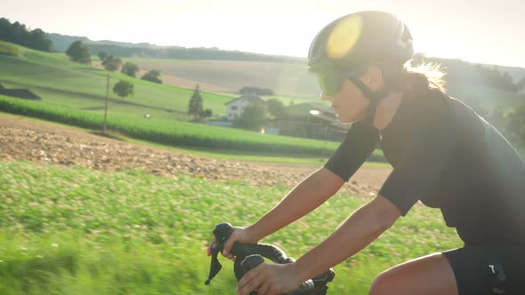 Professional cyclist riding bicycle at sunrise