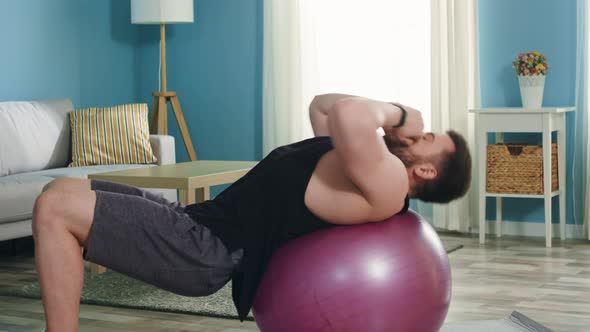 Young Man Is Doing Upper Crunches on Fitness Ball