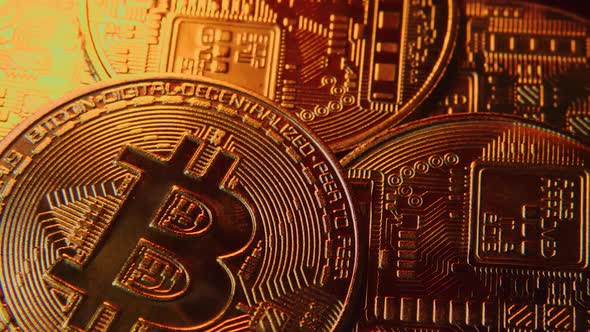 Bitcoin cryptocurrency coins close-up with glints of orange light running across them.