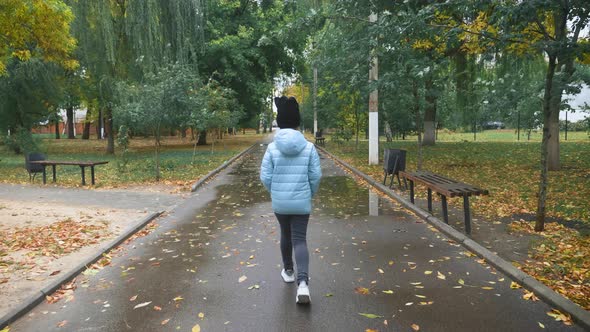 Pretty Girl Walking in the Autumn Park in Rainy Weather.