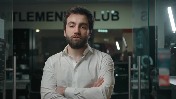 Confident Man with Crossed Arms Standing in Front of a Modern Barbershop Doors / Videohive