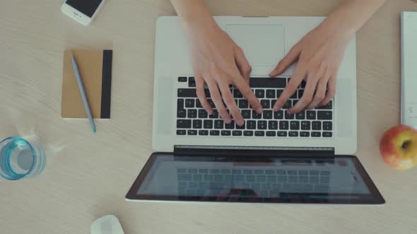 Top view of crop person typing on laptop