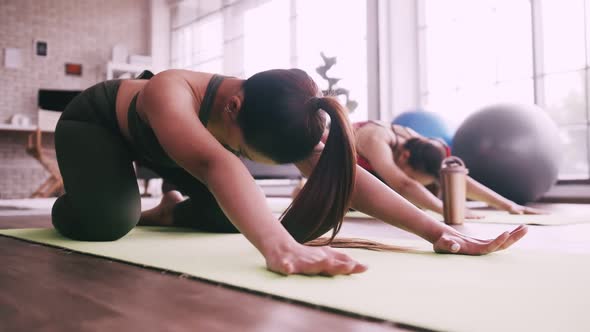 Two Asian girls doing yoga exercises at home.