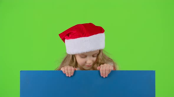 Child in New Year's Clothes Jumps Out From Behind the Board and Shows Ok. Green Screen