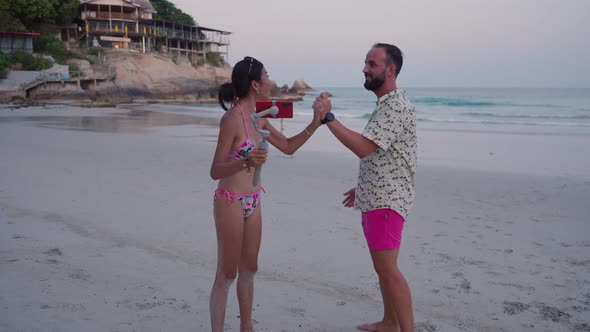 Thai Girl in Bikini Streaming Video From a Sandy Beach at Sunset in Thailand