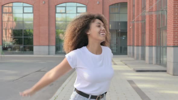 African Woman Dancing While Walking on Street