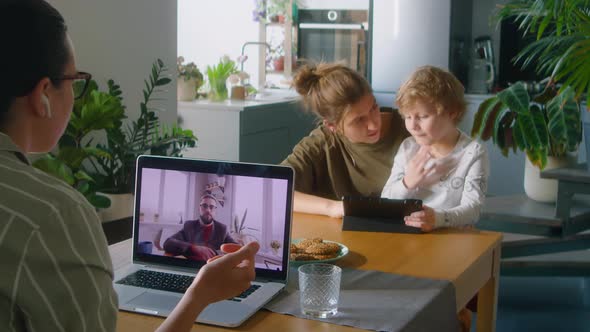 Woman Working from Home while Wife Playing with Kid