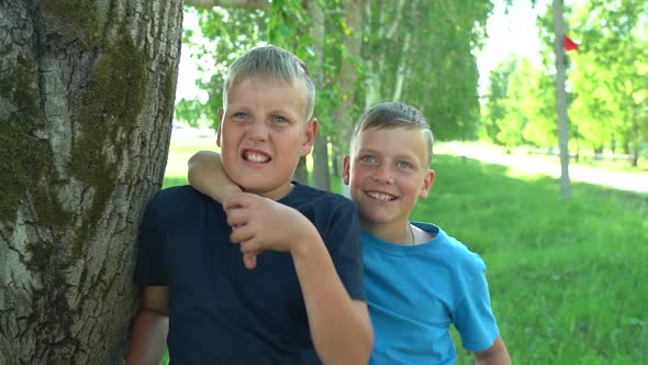 Two Boys 10 and 12 Years Old Hug and Play with Each Other in Front of the Camera