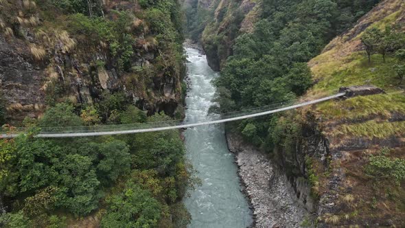 Flying over the Marsyangdi River looking at bridge spanning the canyon