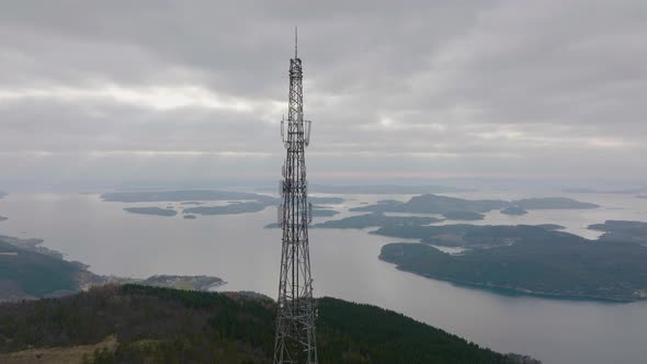 Telephone, 5G and communications tower on mountain top. View of islands on the coast.4K aerial dron