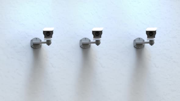 Three Surveillance Cameras On The Wall