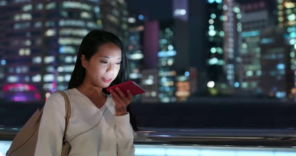 Young woman use of mobile phone in city at night