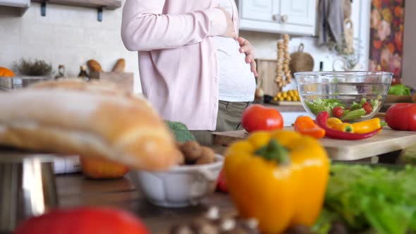 Healthy Eating And Pregnancy Concept. Pregnant Female Cooking Salad.