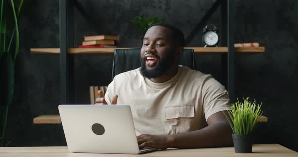 Happy African American Man Having Doing Video Call Using Laptop Computer While Sitting at Home