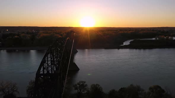 Aerial view of old railroad bridge spanning the Missouri River at sunset