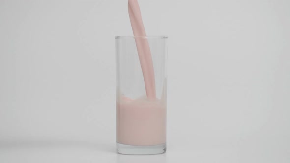 Slow Motion of Pouring Strawberry Milk White Background