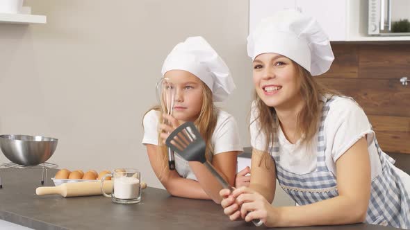 Cheerful Woman and Child Ponder on the Recipe of the Cupcake Concept of Family