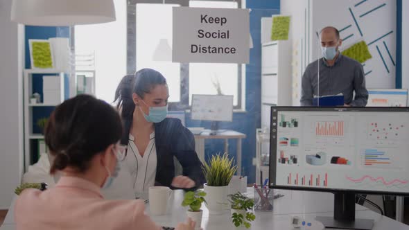 Business People with Medical Face Masks Sitting in New Normal Company Office