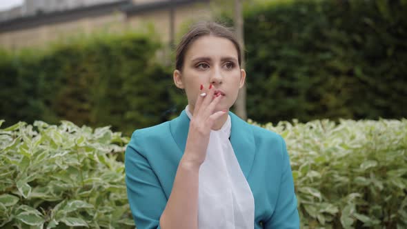 Portrait of Young Stewardess Smoking Outdoors. Beautiful Elegant Slim Caucasian Woman in Blue