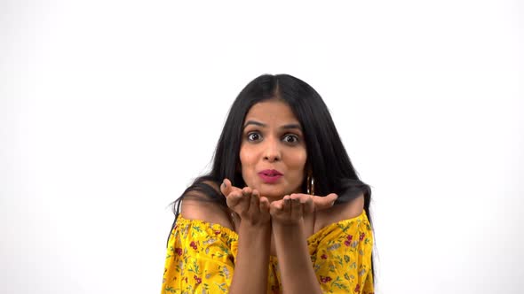 Happy Indian girl blowing a flying kiss