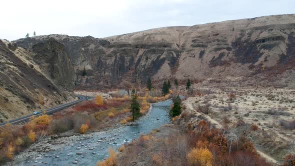 Ariel drone footage of a rugged river valley in fall.