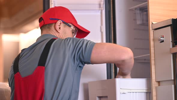 RV Industry Technician Worker Installing Refrigerator