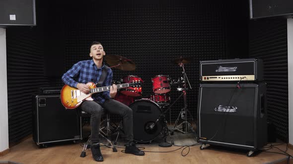 Musician is performing love lyric song on electric guitar on stage at sound recording studio