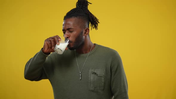 Dissatisfied African American Man Smelling and Tasting Milk Making Disgust Facial Expression