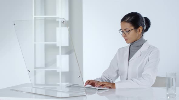 Female Doctor Using PC with Transparent Screen