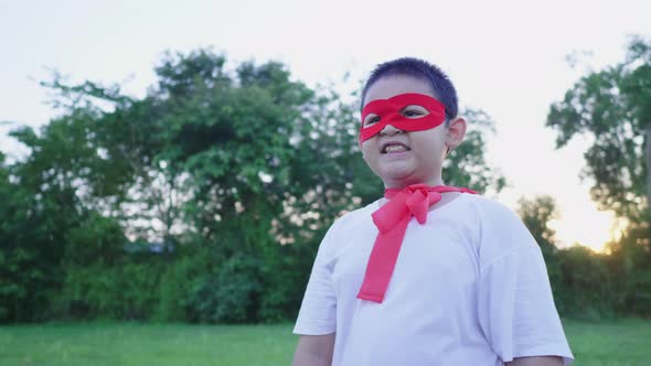 Asian boy wearing hero costume standing and smiling at the park