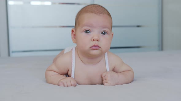 Beautiful Smiling Baby: A Gorgeous Little Baby Lies on the Bed and Smiles at the Camera with a Nice