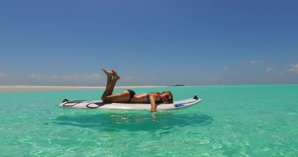 Beautiful smiling ladies on photoshoot having fun at the beach on summer white sand and blue 