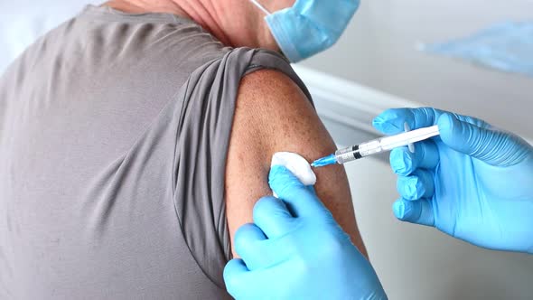 Elderly Man in Face Mask Getting Covid Vaccine