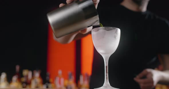 Bartender Pours Mixed Drink From the Shaker to the Frozed Highstemmed Glass Barman Makes Cocktail