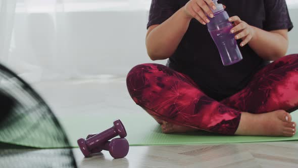 Blonde Overweight Woman Drinks Water From the Bottle on Training