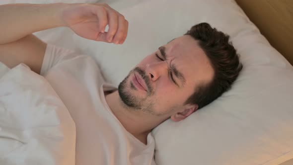 Portrait of Young Man Having Headache in Bed