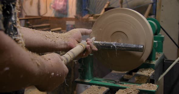 Closeup of carpenter turning wood on a lathe