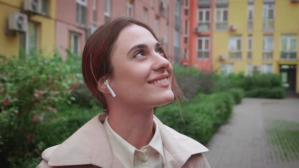 Calm Caucasian Woman Meditate Breathing Fresh Air and with Airpods in Her Ear Listens to Music