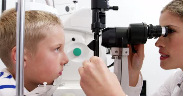 Optometrist examining patient on slit lamp