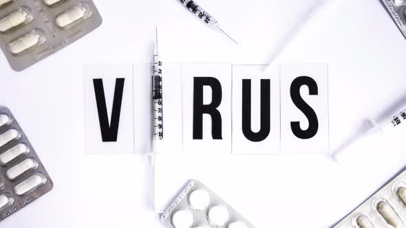 The Word Virus on a White Background with Syringe Pills Medicines  Zoom in Vaccine