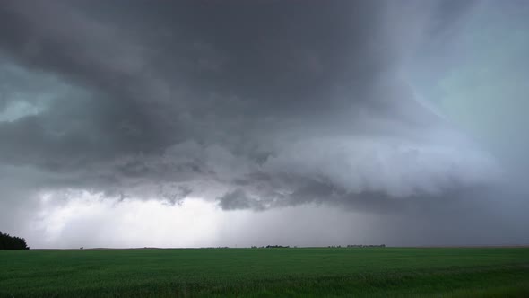 View of severe storm rolling over farm fields in Nebraska as lightning flashes