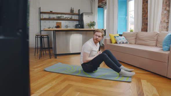 Fit Young Man Doing Abs Workout on Floor in Front of Tv at Home