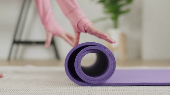 Close up hands woman unrolling exercise mats before the start of fitness.