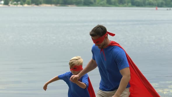 Father Helps Son to Jump Higher, Superhero Family Team, Togetherness Slow-Mo