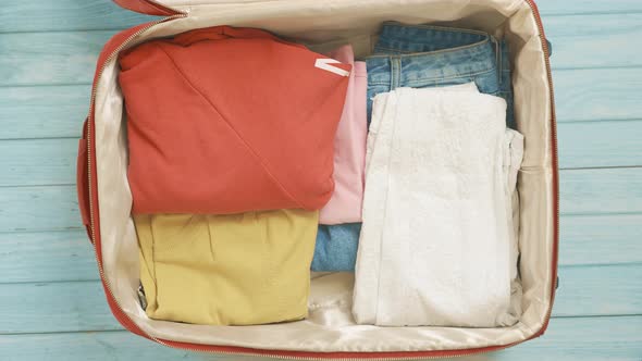 A Traveler Woman is Getting Ready for Travel and Packing Clothes