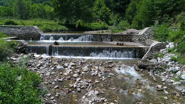 Weirs on the stream. Artificial waterfall flow of water.