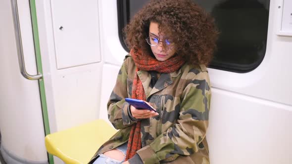 Slow motion young multiethnic women travelling underground using smart phone