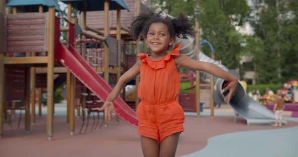 Adorable Afroamerican Toddler Girl Jump on Playground