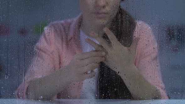 Sad Lady Taking Off Engagement Ring, Looking to Rainy Window, Broken Relations