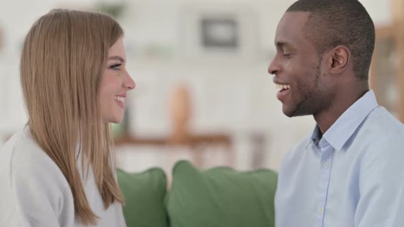Happy Mixed Race Couple Smiling at Each Other Lovingly at Home